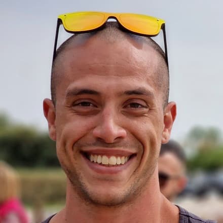 Michalis Tsakonas, smiling outdoors on a summer day
